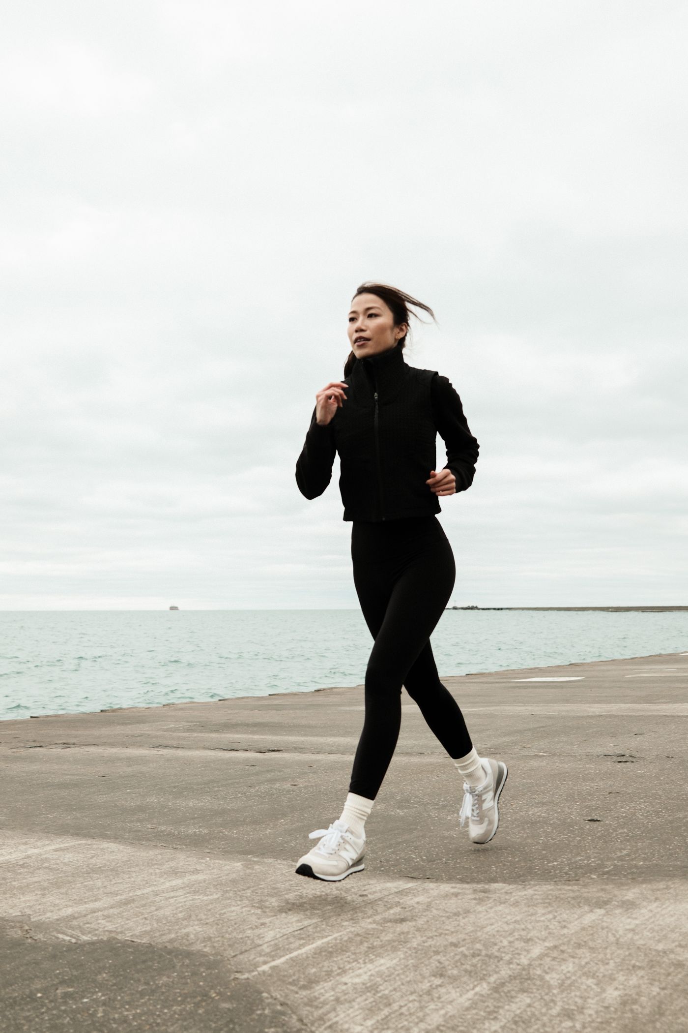 A woman on a morning run along a marina waterfront